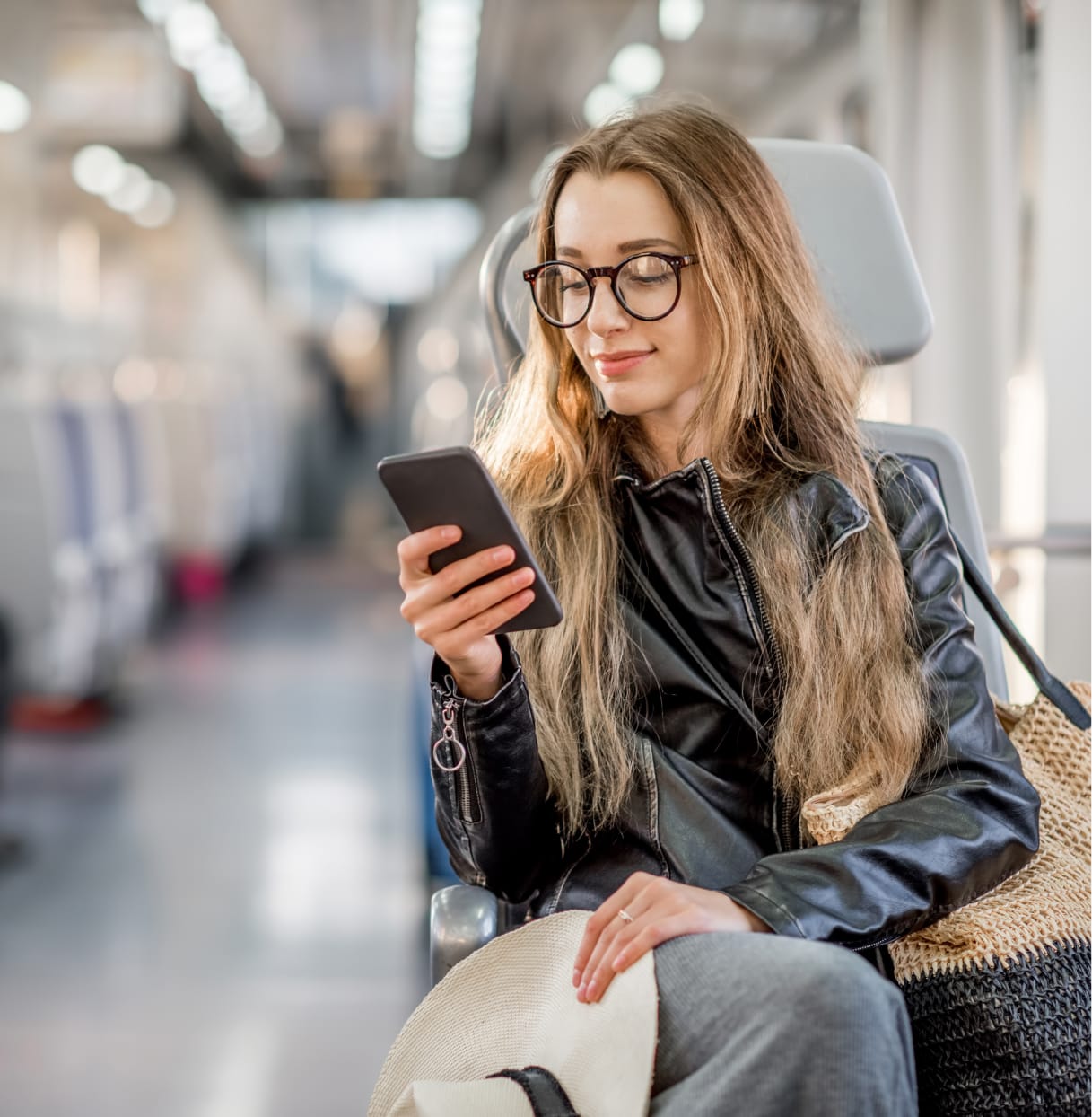 A young woman on her phone whilst travelling by train.