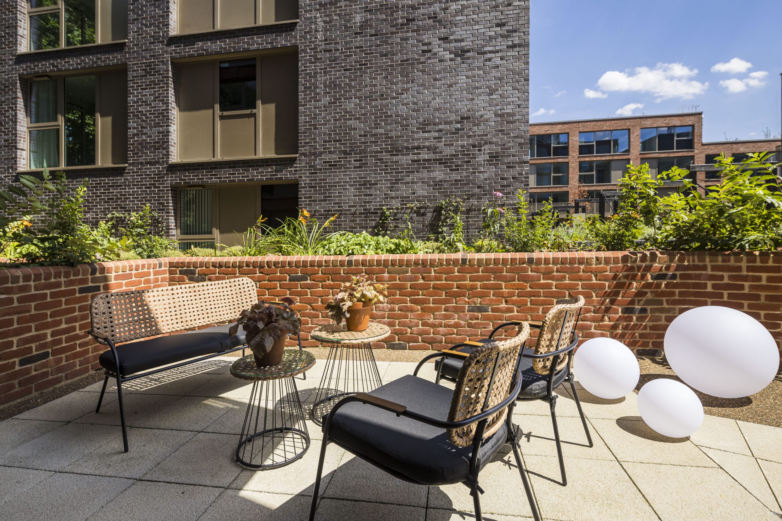 A private outdoor terrace featuring lounge furniture such as rattan chairs and coffee tables.