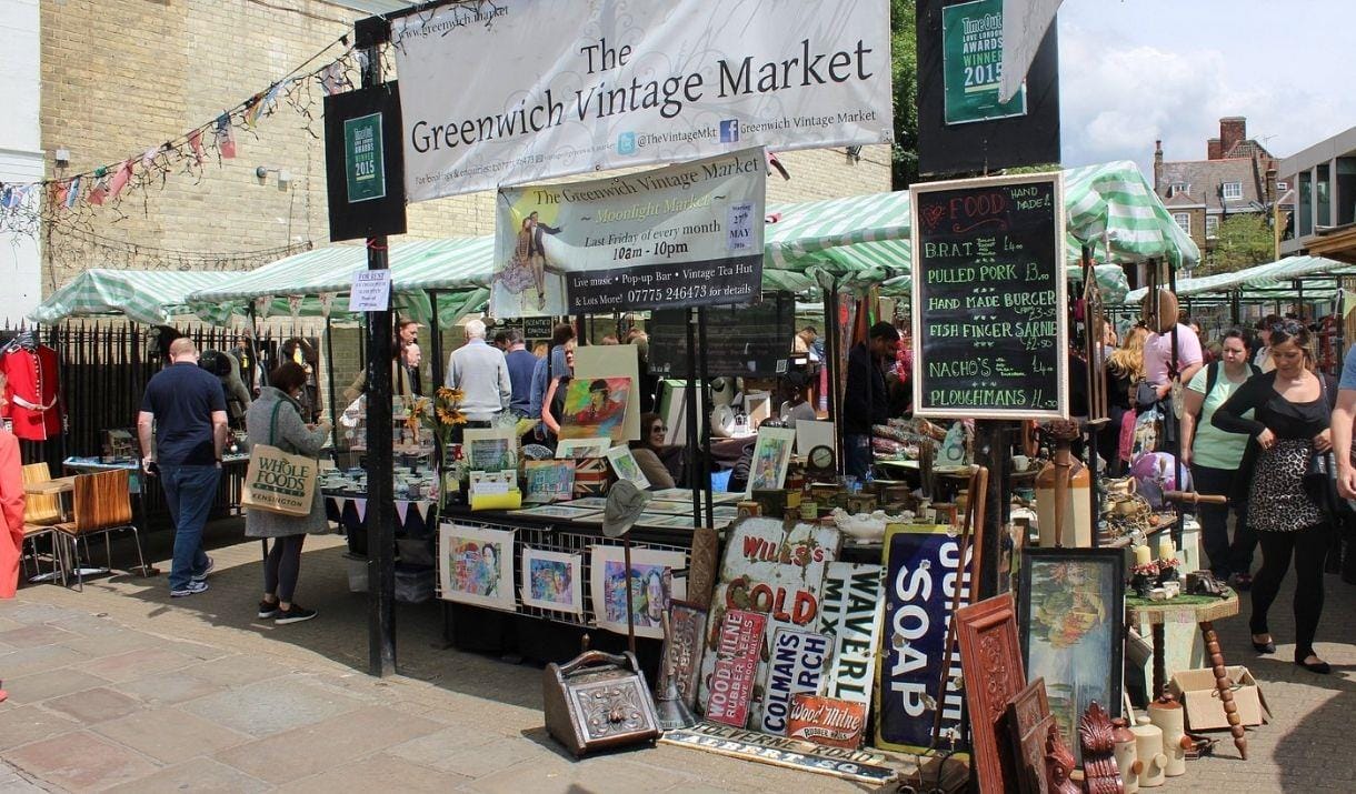 A stall at The Greenwich Vintage Market with various artworks, antiques and food for sale.