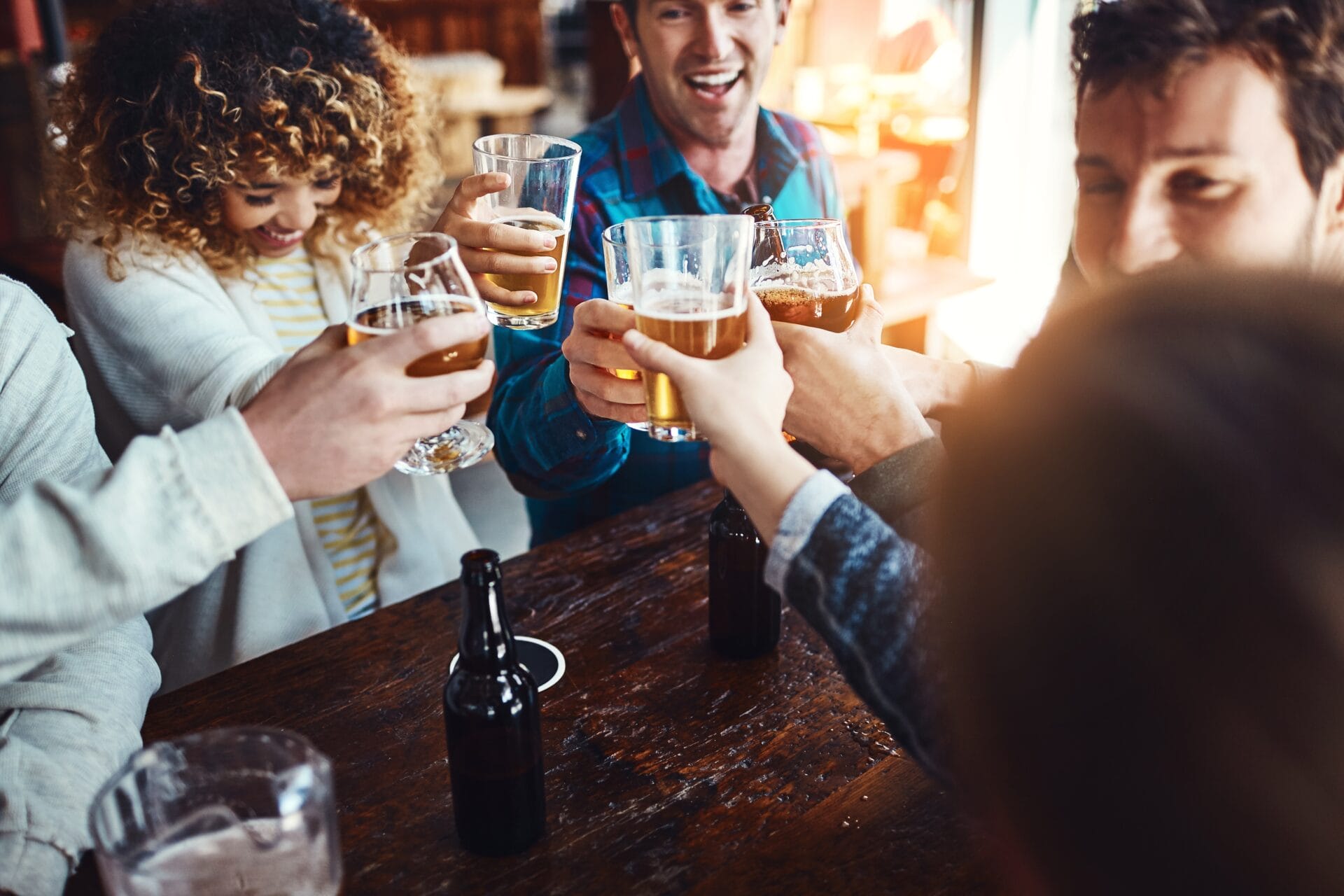 A group of friends clinking glasses at a pub.