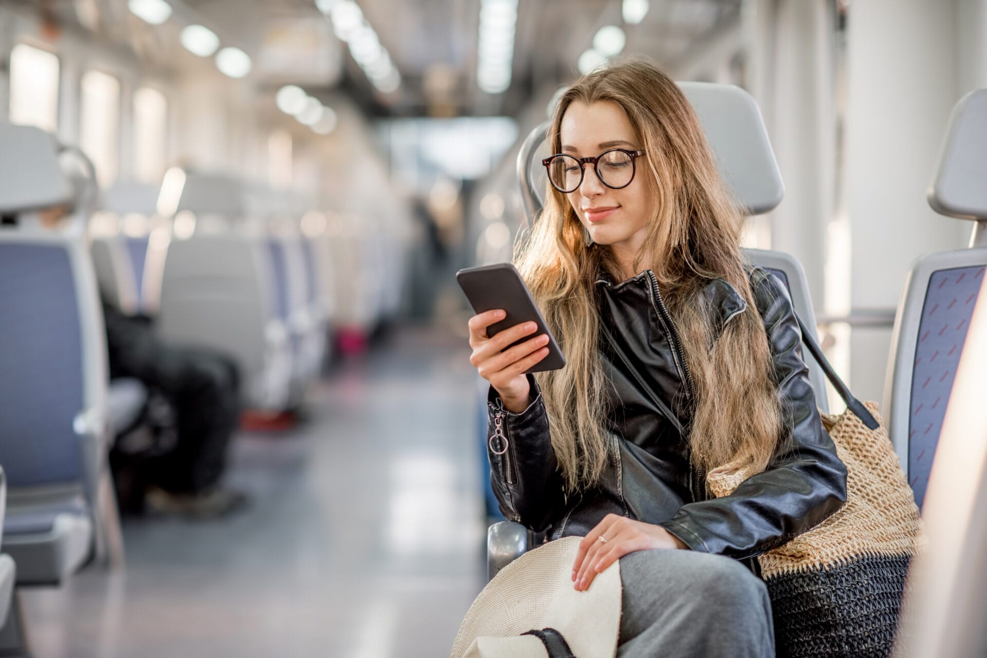 A young woman on her phone whilst travelling by train.