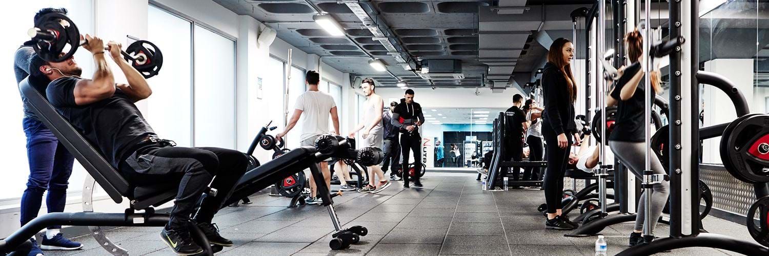 A gym full of people exercising using the equipment.