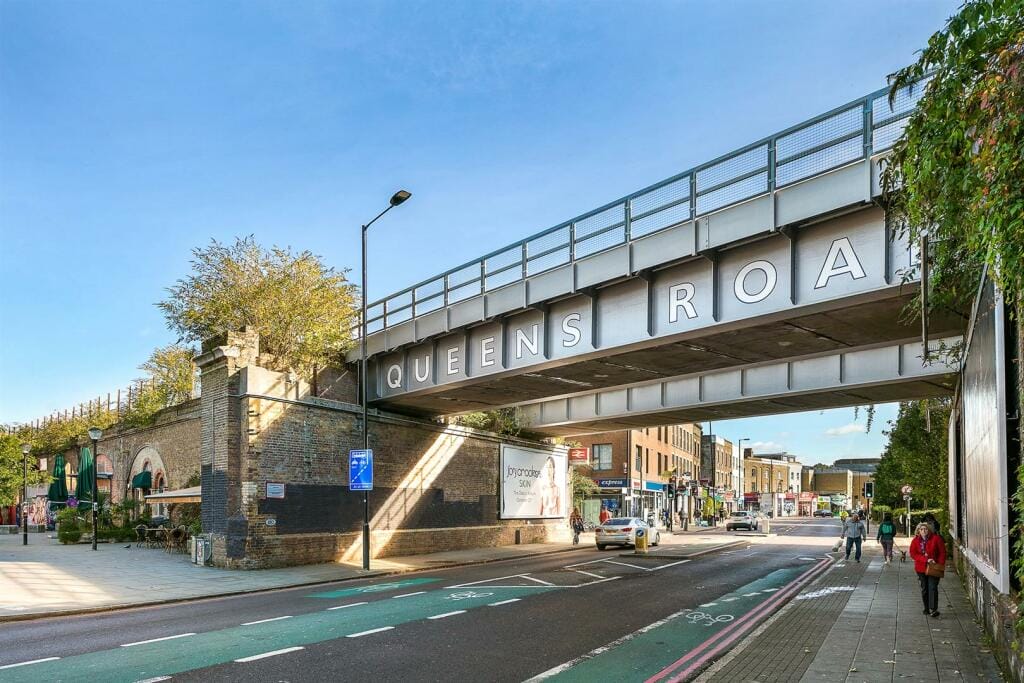 An exterior street view of Queens Road Station and bridge.
