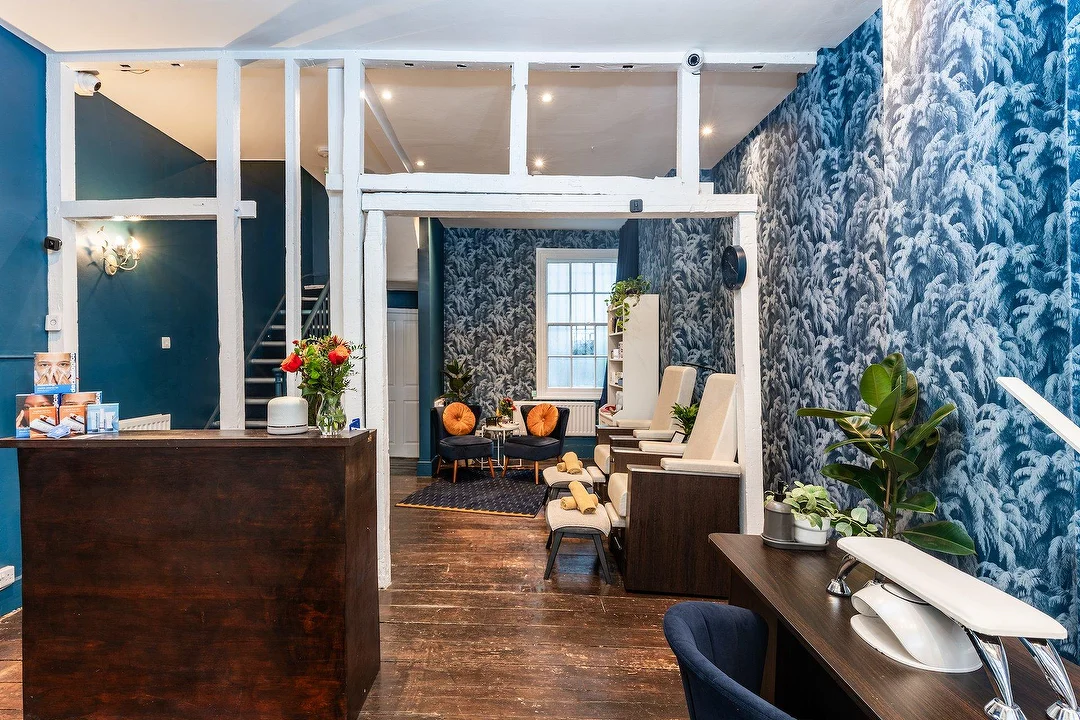 The interior of The Greenwich Spa. There is a front desk and several spa chairs.