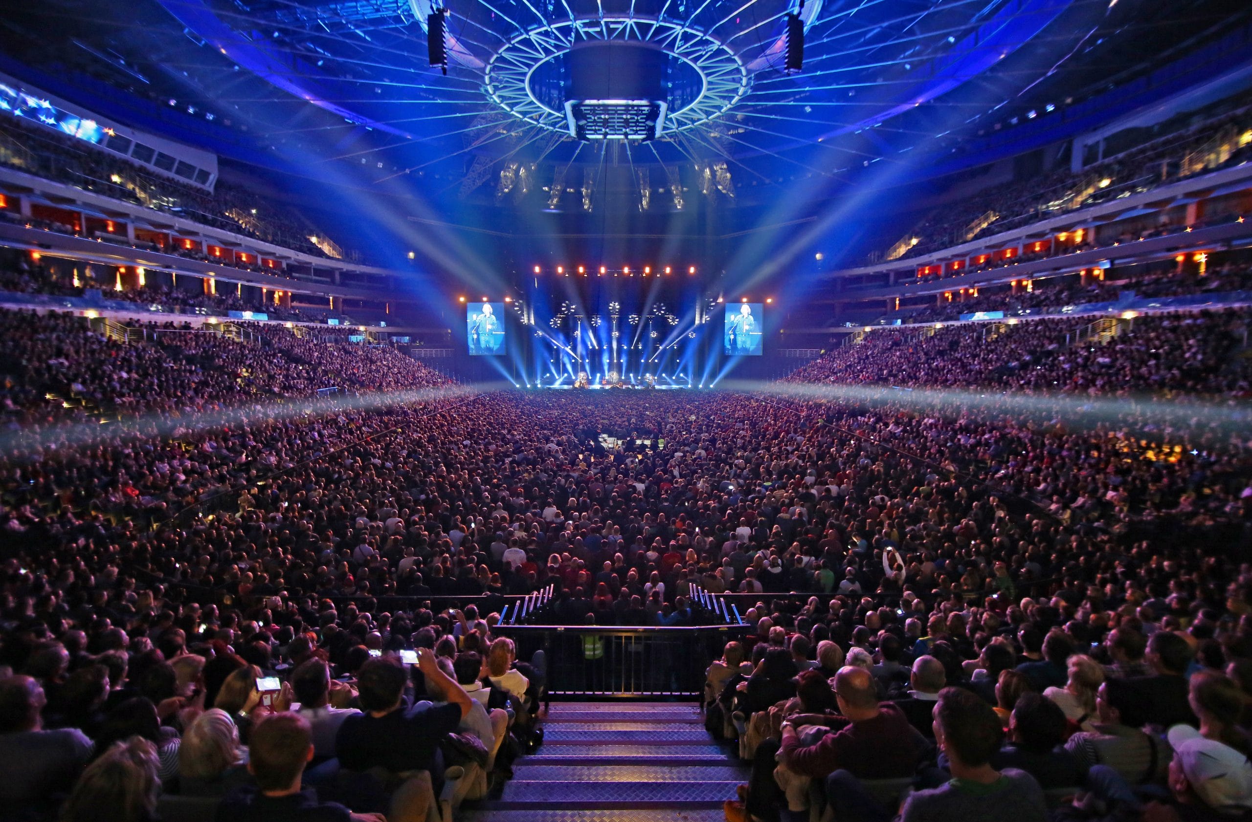The inside of the O2 Arena main stage during a live music performance. The venue is full of people enjoying the show.