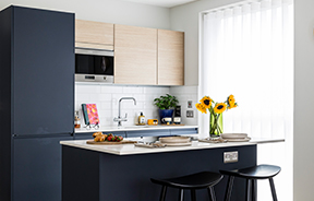 A kitchen with a breakfast bar island at Neptune Wharf