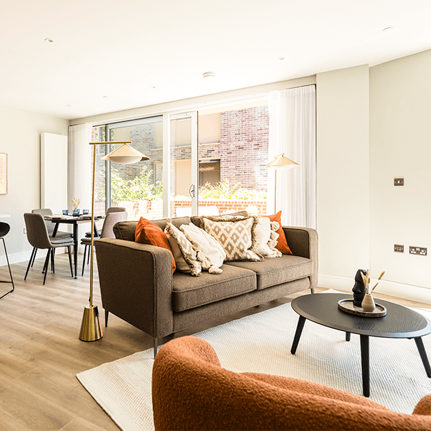 A view of the living/dining area which leads outside to the private terrace. There is a sofa, armchair, coffee table, dining table and breakfast bar.